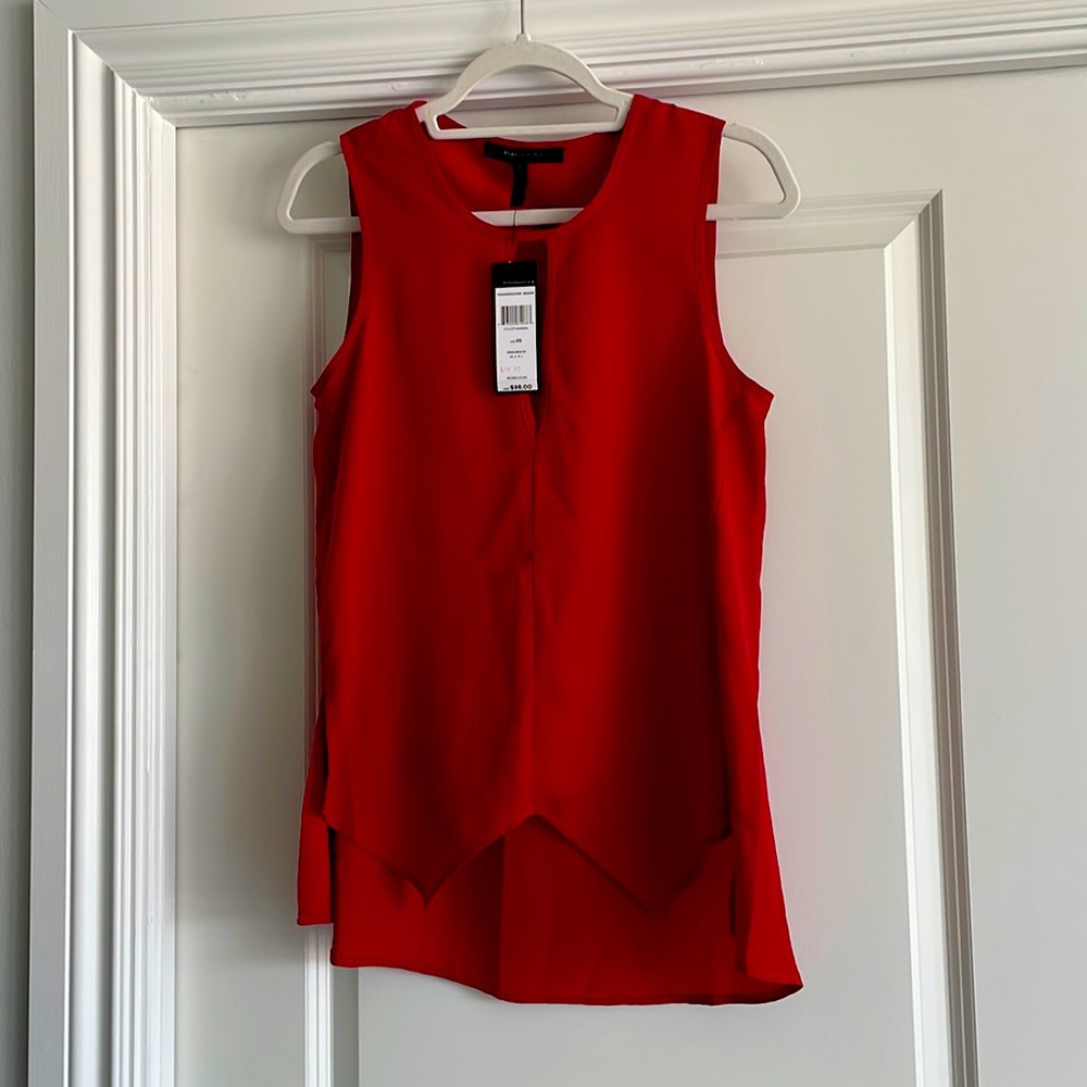 BCBG sleeveless top-handkerchief type bottom in the front & Longer in the back.
